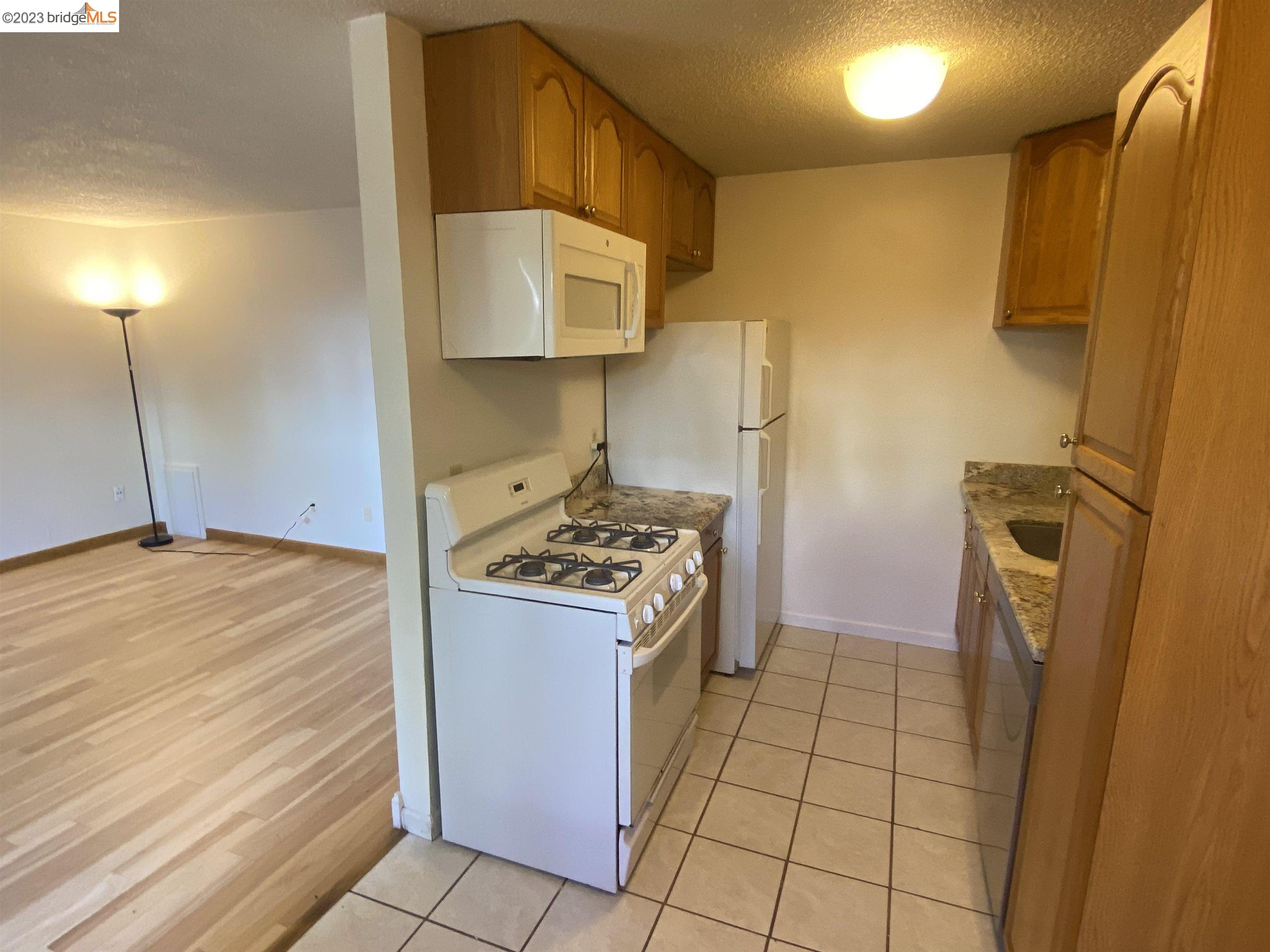 968 45th Street, Unit A Oakland, CA 94608 - Photo 6 of 16 a kitchen with a stove a refrigerator and cabinets