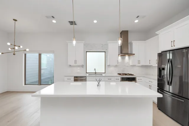 a kitchen with kitchen island a sink stainless steel appliances and cabinets