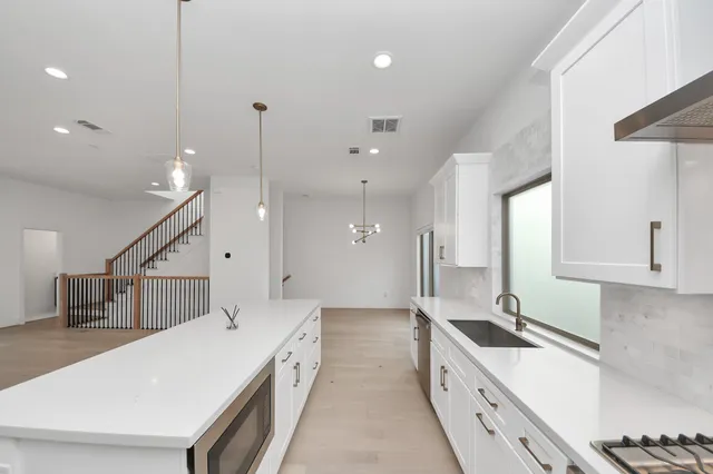 a large kitchen with kitchen island a sink a counter space and a stove