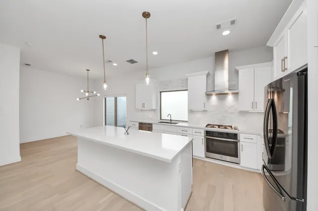 a kitchen with kitchen island a sink stainless steel appliances and cabinets