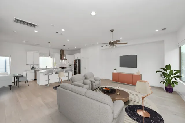 a living room with furniture kitchen view and a potted plant
