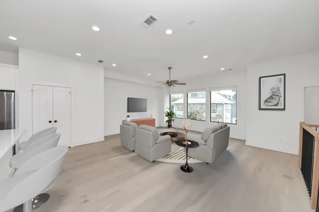 a living room with furniture a flat screen tv and a large window