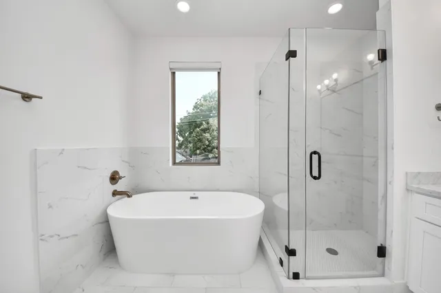 a white bath tub sitting next to a shower