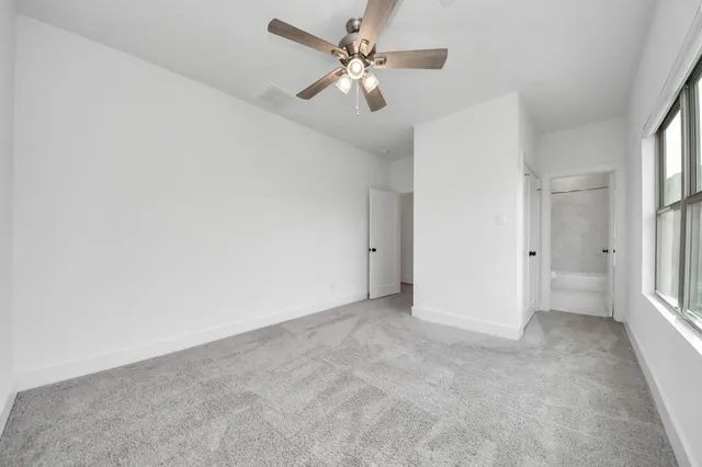 an empty room with fan and windows