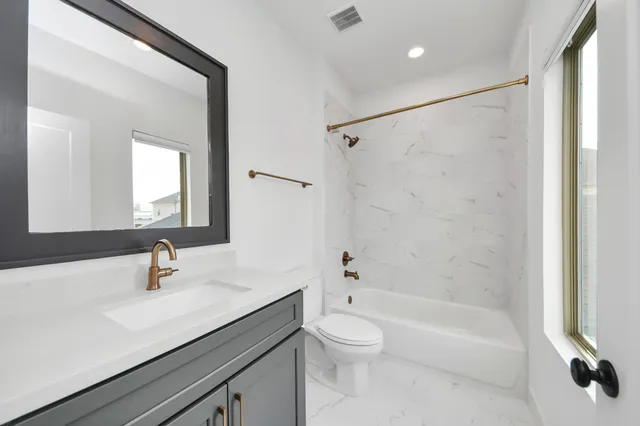 a bathroom with a sink a toilet a mirror and shower