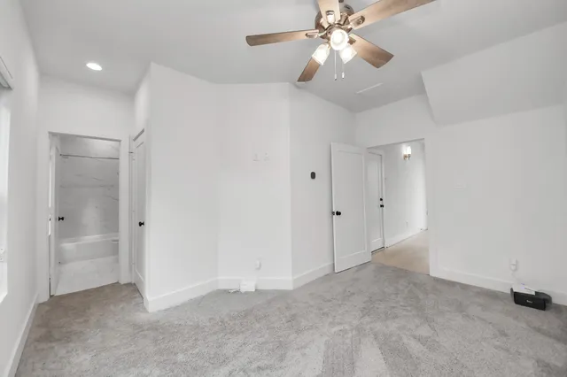 wooden floor in an empty room with a chandelier fan