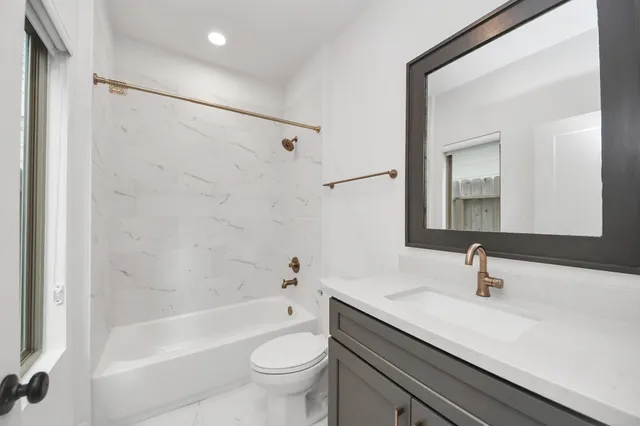 a bathroom with a sink a toilet a mirror and shower