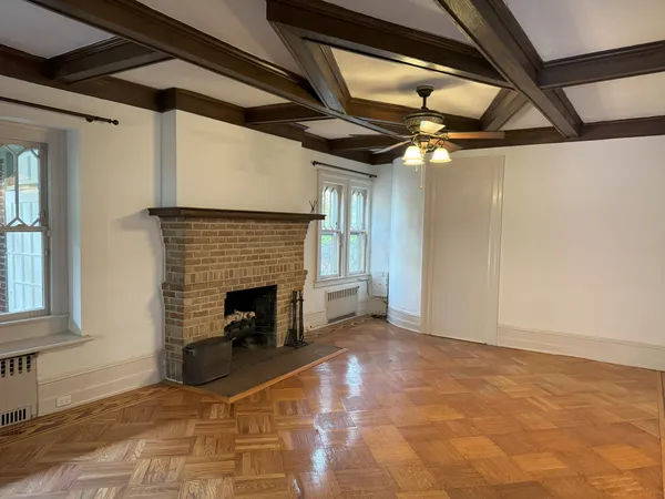 a view of an empty room with a fireplace and a window