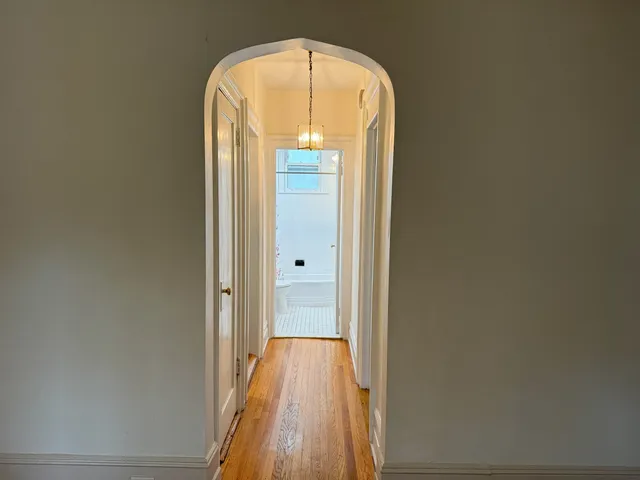 a view of a hallway with wooden floor