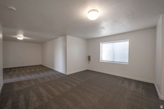 11922 Bluff View Drive Sandy, UT 84092 - Photo 18 of 30 Empty room with dark colored carpet and a smoke detector