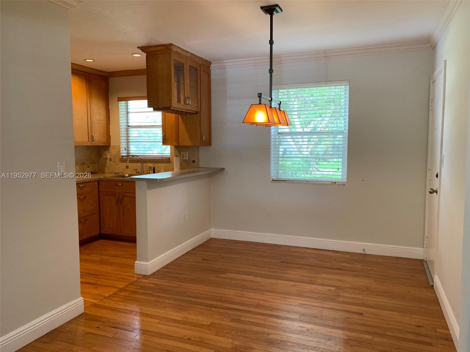 7840 Southwest 55th Avenue, Unit 22A Miami, FL 33143 - Photo 5 of 16 a kitchen with granite countertop white cabinets and a wooden floor