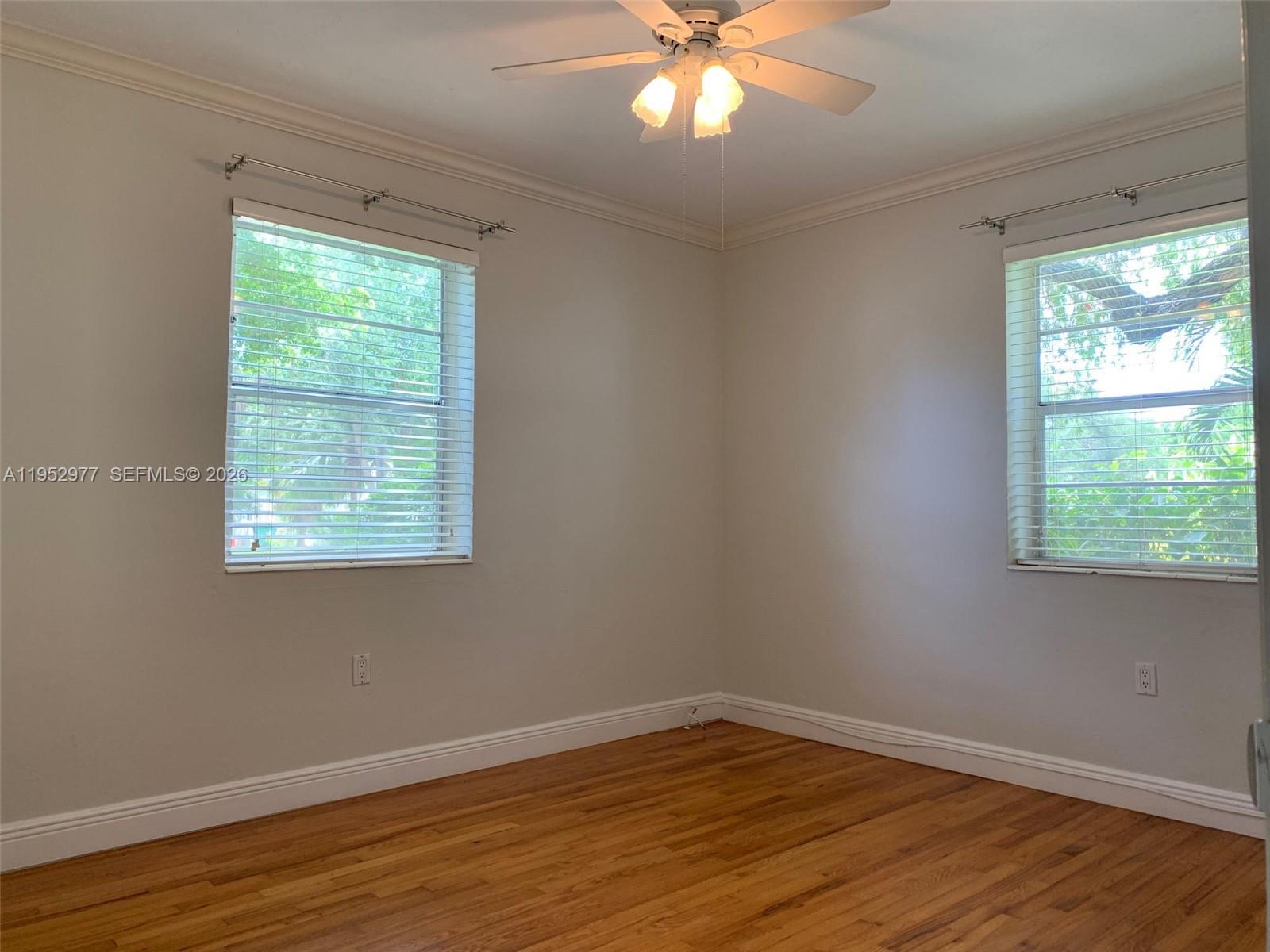 7840 Southwest 55th Avenue, Unit 22A Miami, FL 33143 - Photo 9 of 16 a view of an empty room with wooden floor and a window