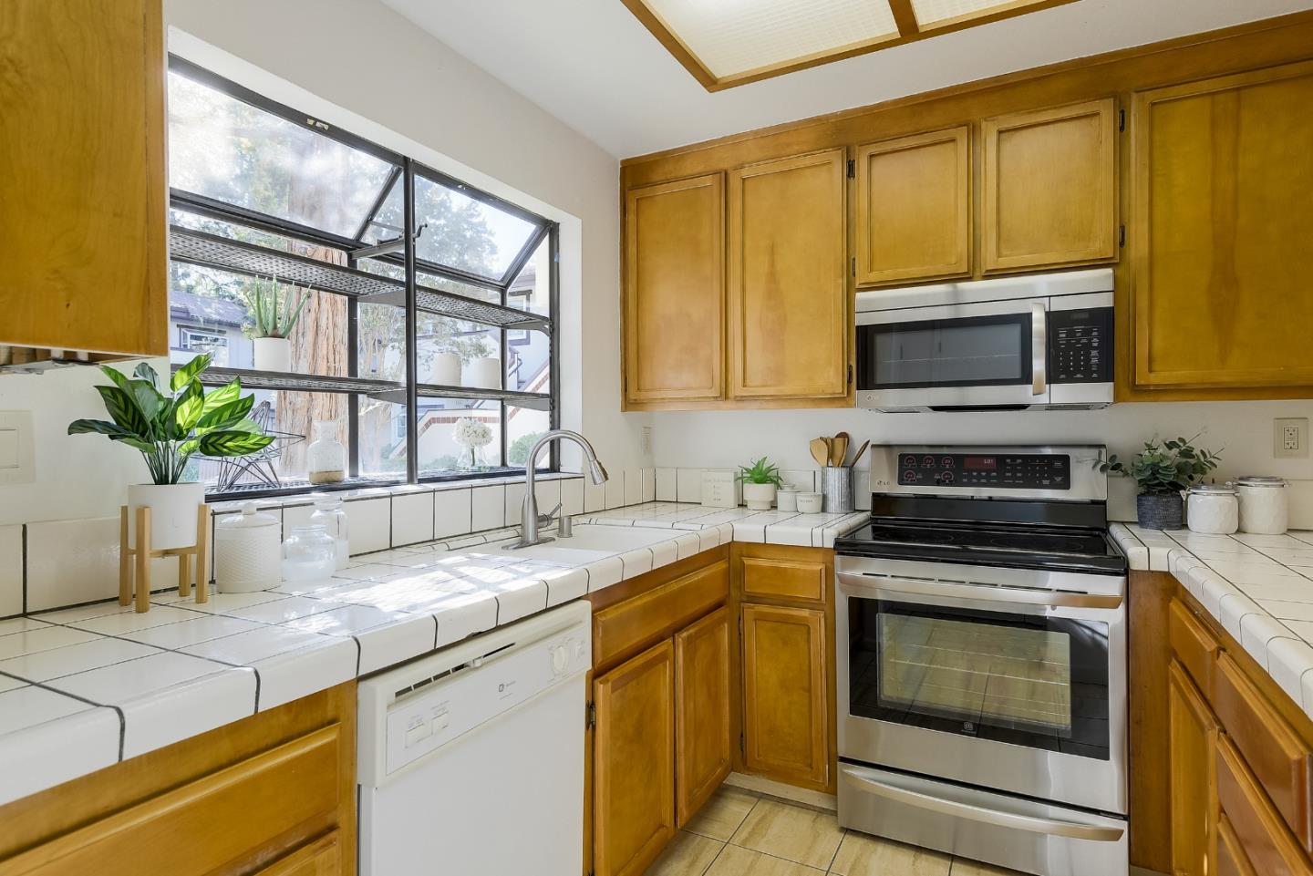 1400 Bowe Avenue, Unit 302 Santa Clara, CA 95051 - Photo 6 of 16 a kitchen with stainless steel appliances granite countertop white cabinets a window and a sink