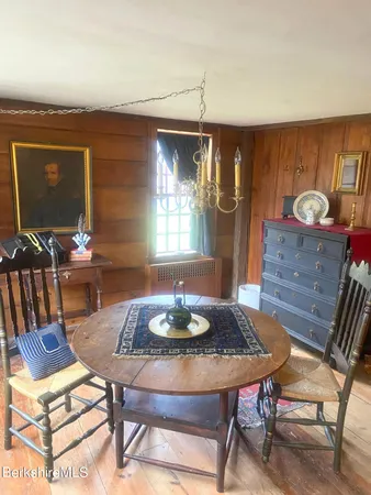 a dining room with furniture a chandelier and wooden floor