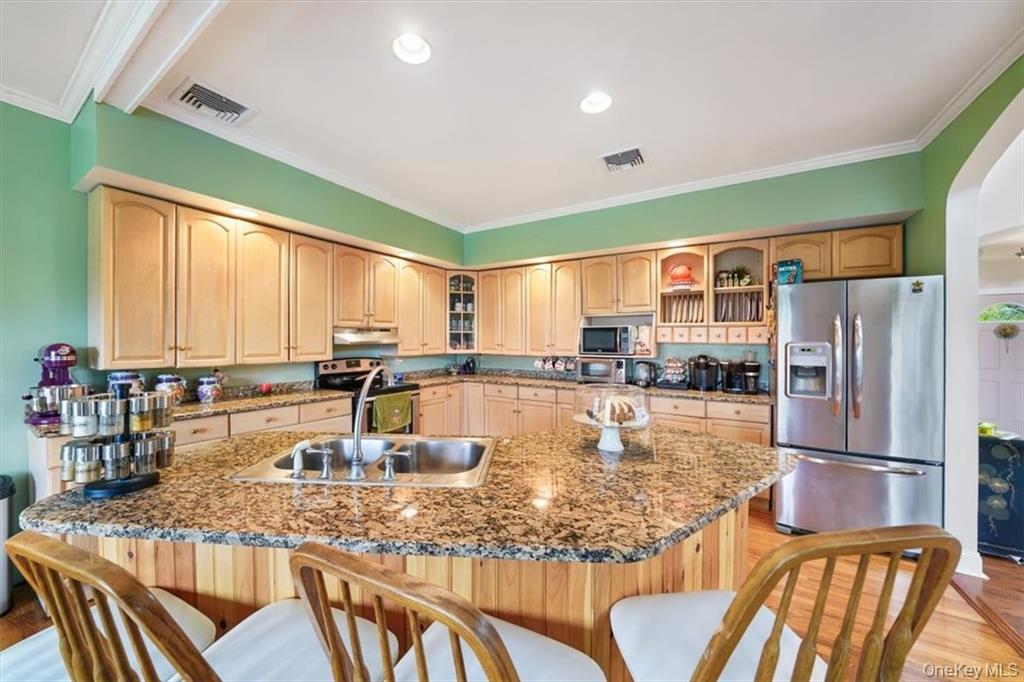 2 Bruyn Avenue Pine Bush, NY 12566 - Photo 4 of 9 a kitchen with stainless steel appliances granite countertop a refrigerator a stove and white cabinets with wooden floors