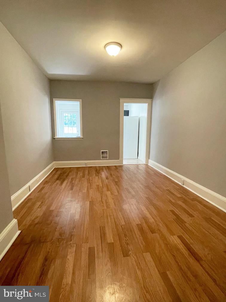 3609 Brooklyn Avenue Baltimore, MD 21225 - Photo 11 of 41 an empty room with wooden floor and windows