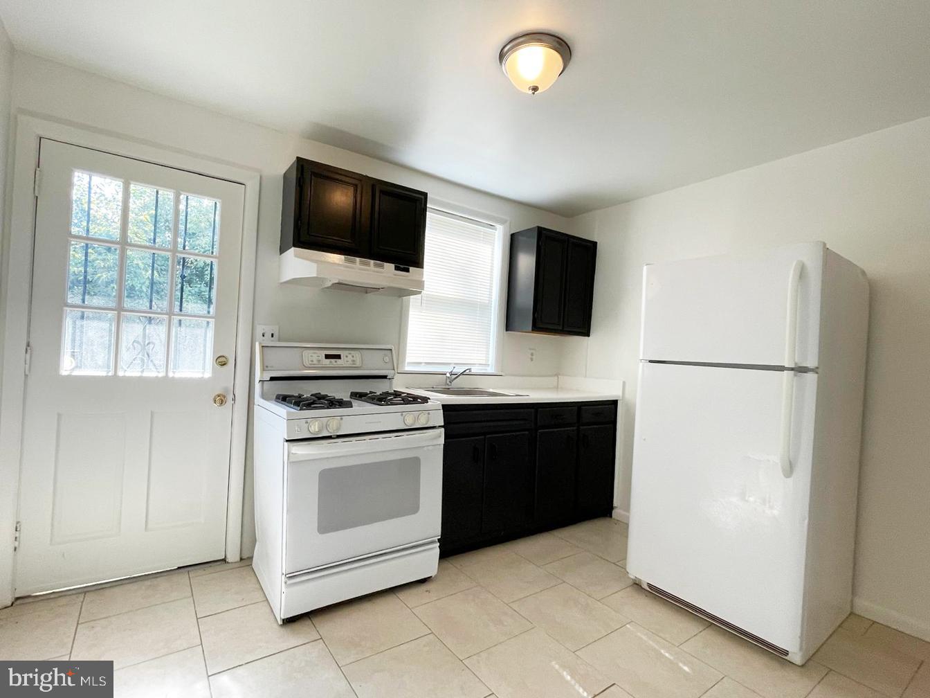 3609 Brooklyn Avenue Baltimore, MD 21225 - Photo 12 of 41 a kitchen with a refrigerator stove and microwave