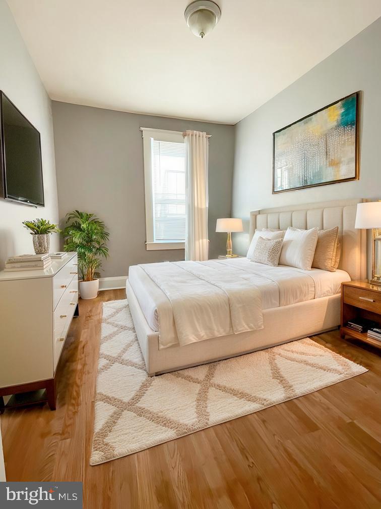 3609 Brooklyn Avenue Baltimore, MD 21225 - Photo 13 of 41 a bedroom with a large bed a flat screen tv and a couch