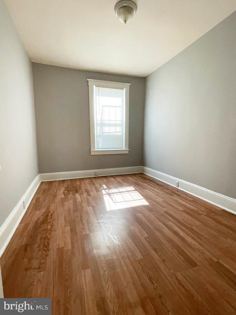 3609 Brooklyn Avenue Baltimore, MD 21225 - Photo 14 of 41 an empty room with wooden floor and windows