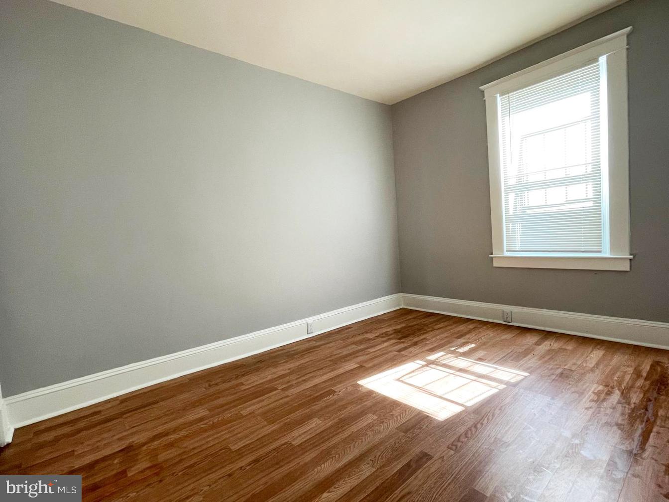 3609 Brooklyn Avenue Baltimore, MD 21225 - Photo 17 of 41 an empty room with wooden floor and windows