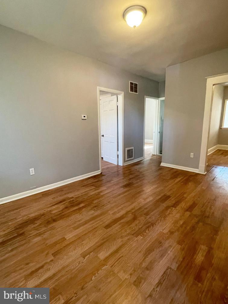 3609 Brooklyn Avenue Baltimore, MD 21225 - Photo 6 of 41 an empty room with wooden floor and windows