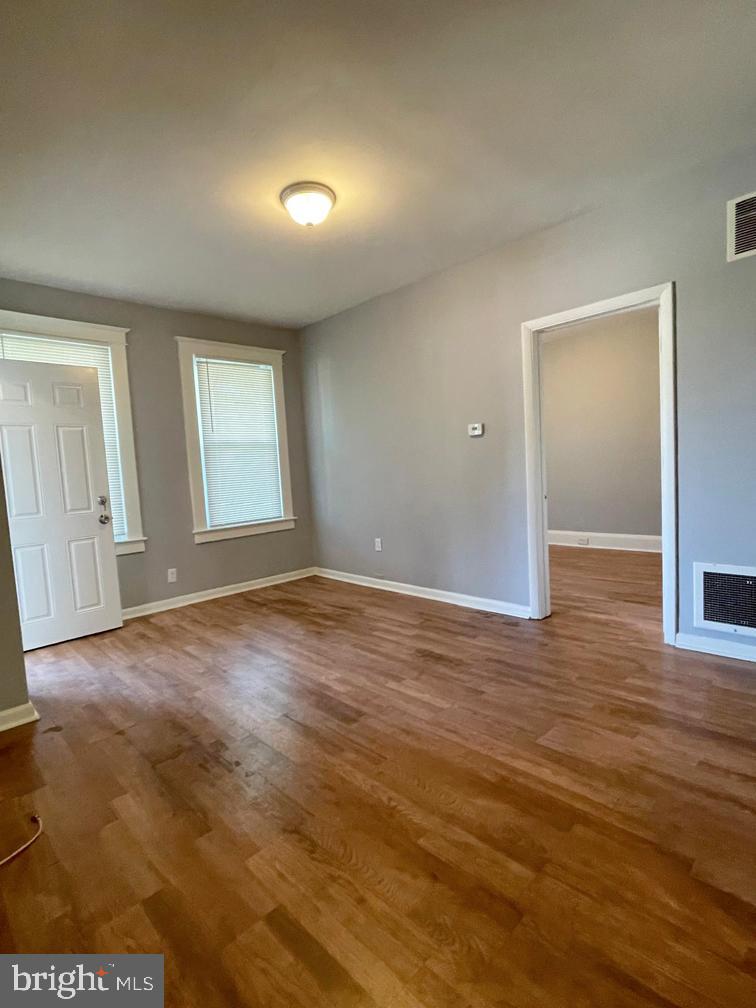 3609 Brooklyn Avenue Baltimore, MD 21225 - Photo 8 of 41 an empty room with wooden floor and windows