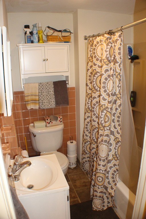 43 Farmland Road Lowell, MA 01850 - Photo 15 of 27 a bathroom with a toilet and a shower curtain