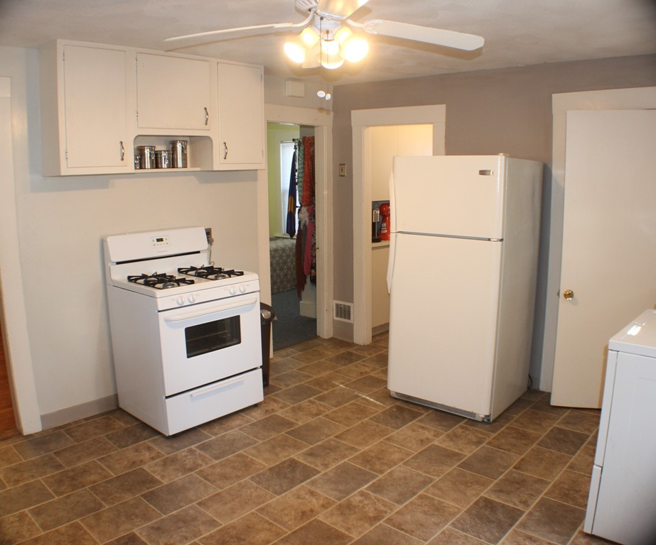 43 Farmland Road Lowell, MA 01850 - Photo 7 of 27 a white refrigerator freezer and a stove sitting inside of a kitchen