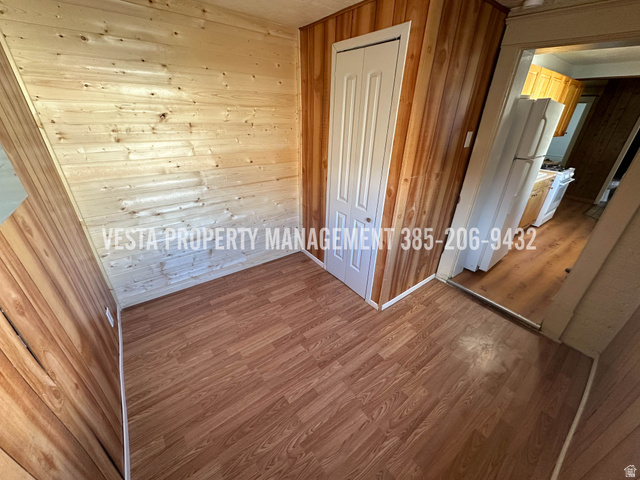 471 East 22nd Street Ogden, UT 84401 - Photo 7 of 12 Unfurnished bedroom with wood walls, a closet, freestanding refrigerator, and wood finished floors