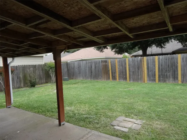 a view of a backyard with wooden fence