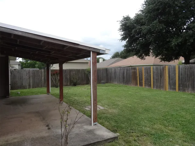 a view of a backyard with wooden fence