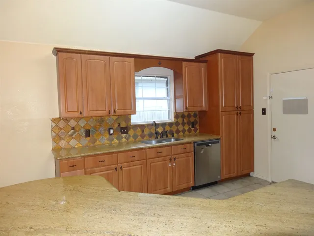 a kitchen with stainless steel appliances granite countertop a sink and a refrigerator