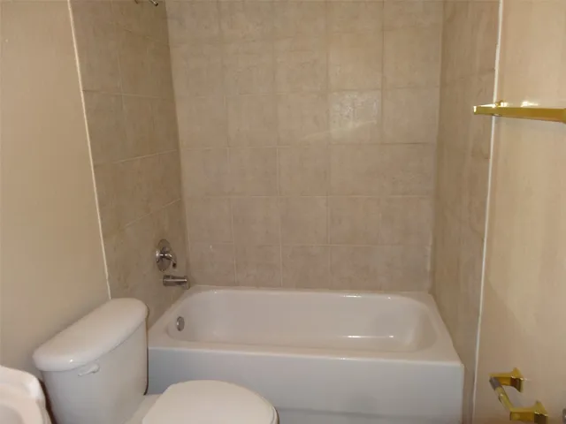 a white bath tub sitting next to a white toilet and a sink