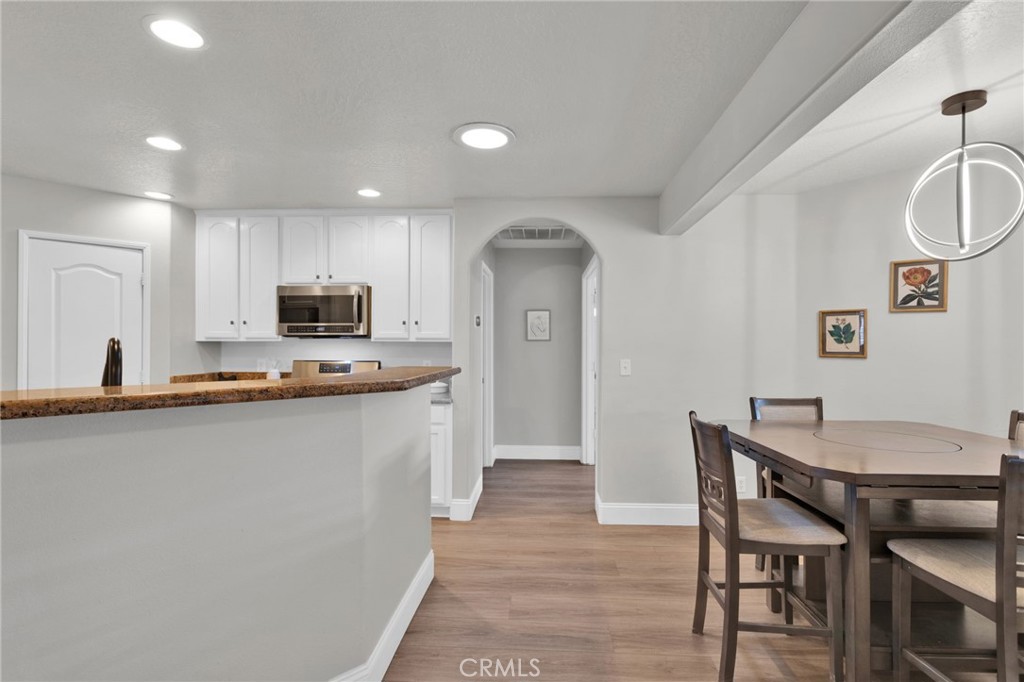 11410 Cibola Road Apple Valley, CA 92308 - Photo 16 of 45 a kitchen with stainless steel appliances a dining table chairs and microwave
