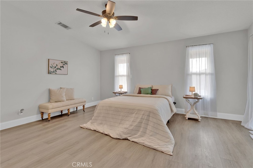 11410 Cibola Road Apple Valley, CA 92308 - Photo 19 of 45 a spacious bedroom that has a bed and chair