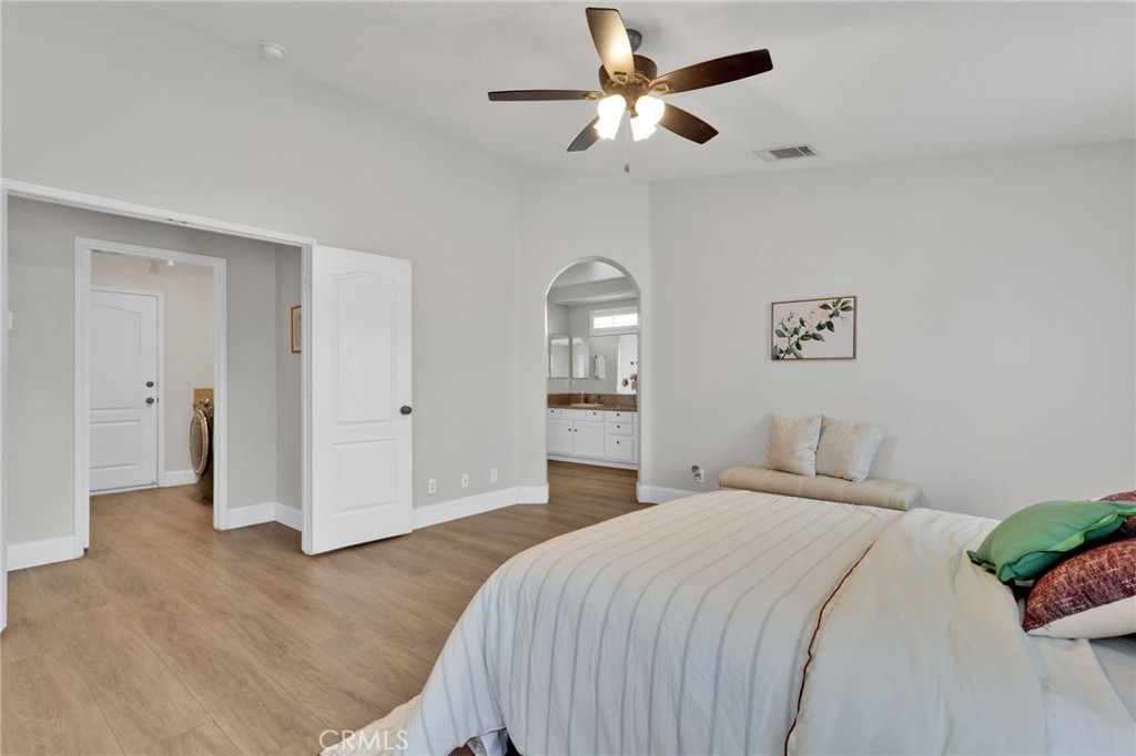 11410 Cibola Road Apple Valley, CA 92308 - Photo 20 of 45 a bedroom with a large bed and a chandelier