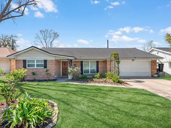 a front view of a house with a big yard and potted plants