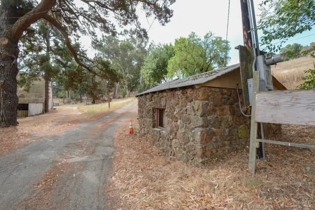 a stone house with trees in front of it