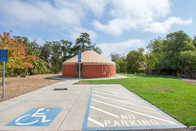 a view of a backyard with table and chairs plants and wooden fence