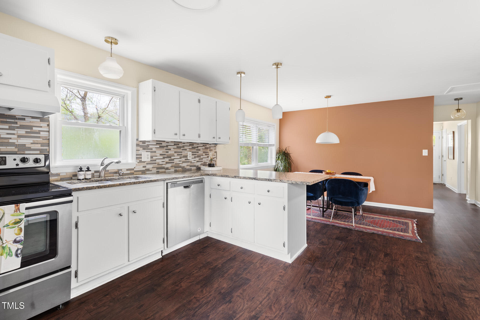 1234 Berkeley Street Durham, NC 27705 - Photo 28 of 46 a kitchen with stainless steel appliances granite countertop a stove a sink dishwasher and a microwave with wooden floor