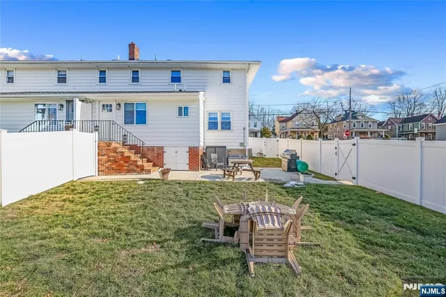 a view of a chair and table in the back yard of the house