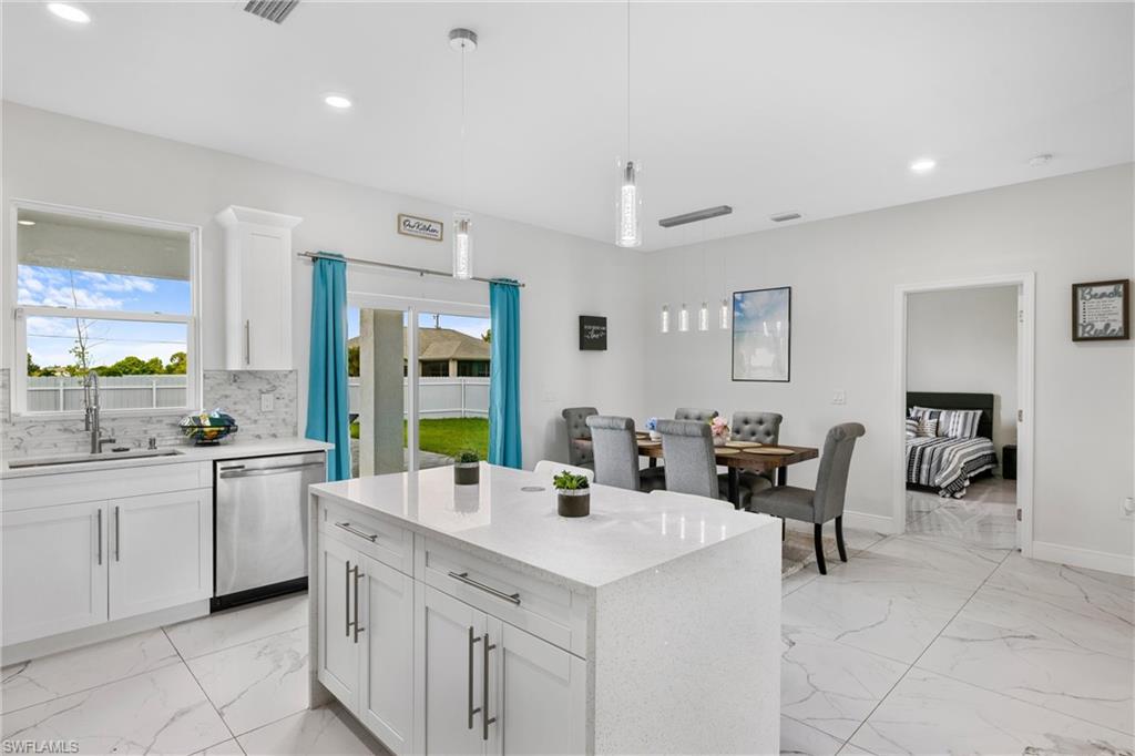 110 Nelson Road South Cape Coral, FL 33991 - Photo 13 of 27 a large kitchen with kitchen island a sink a counter space and appliances