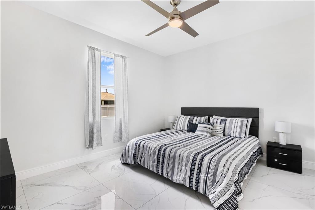 110 Nelson Road South Cape Coral, FL 33991 - Photo 15 of 27 a bedroom with a bed and wooden floor