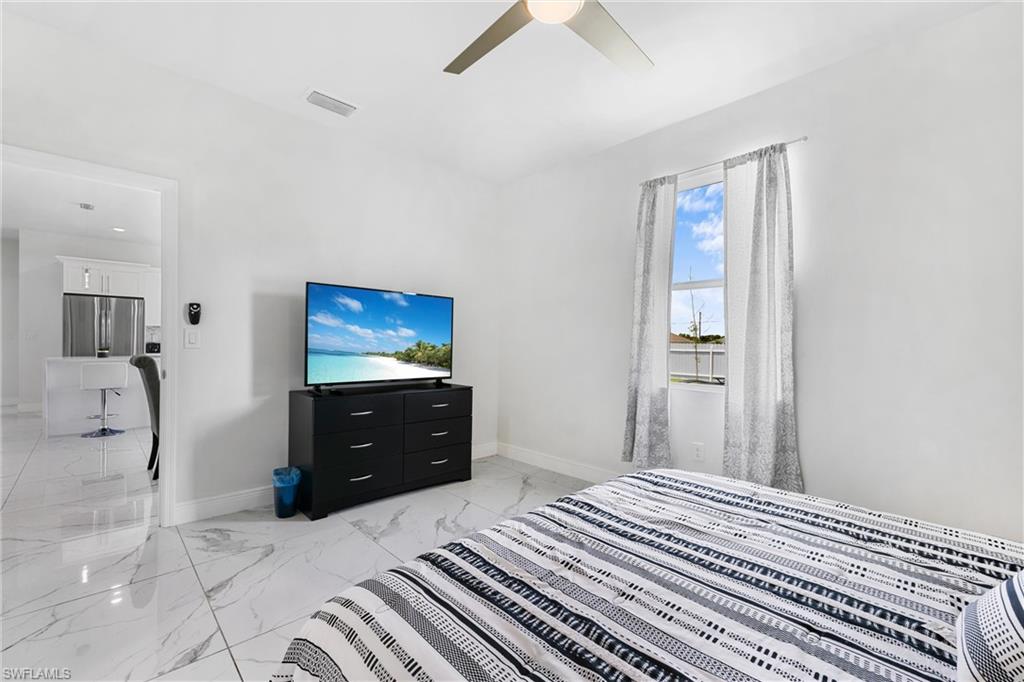 110 Nelson Road South Cape Coral, FL 33991 - Photo 16 of 27 a bedroom with a bed and a chandelier