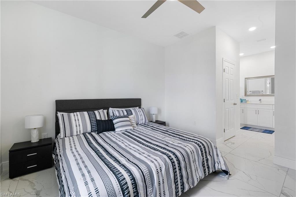 110 Nelson Road South Cape Coral, FL 33991 - Photo 17 of 27 a bedroom with a bed and a view of bathroom