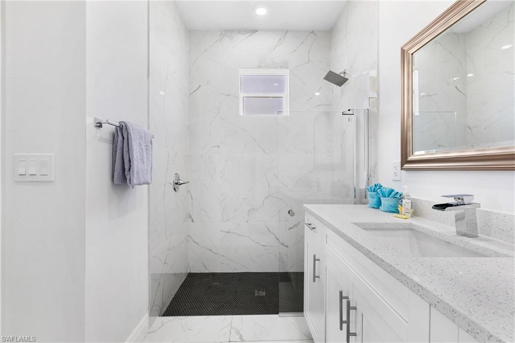 110 Nelson Road South Cape Coral, FL 33991 - Photo 19 of 27 a bathroom with a sink a toilet a shower and a window