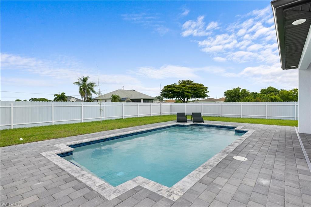 110 Nelson Road South Cape Coral, FL 33991 - Photo 26 of 27 a view of a swimming pool with an outdoor seating and a yard