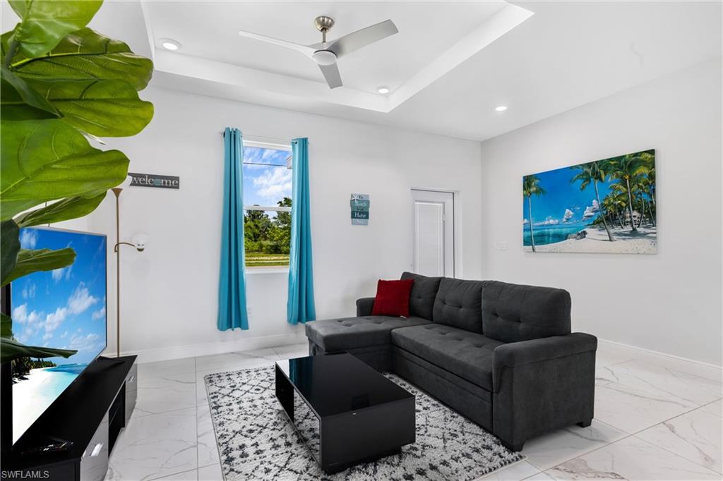 110 Nelson Road South Cape Coral, FL 33991 - Photo 3 of 27 a living room with furniture a couch and a flat screen tv