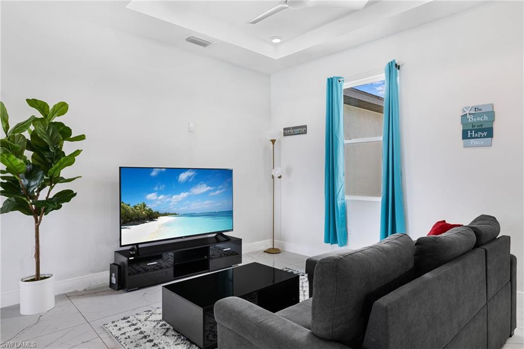110 Nelson Road South Cape Coral, FL 33991 - Photo 4 of 27 a living room with furniture and a flat screen tv