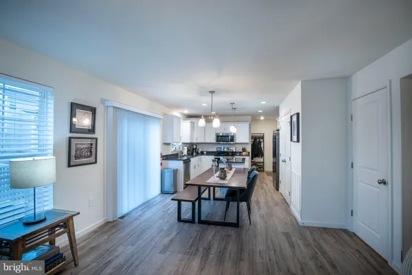 a view of a dining room and livingroom with furniture wooden floor a chandelier